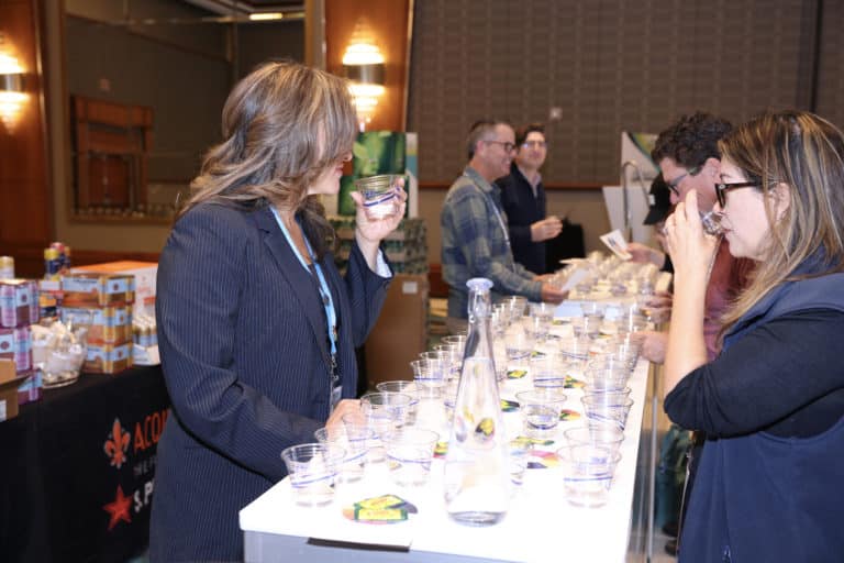 Attendees sampling water at a Vivreau event booth, featuring water tasting stations with multiple glasses and a focus on hydration and sustainability