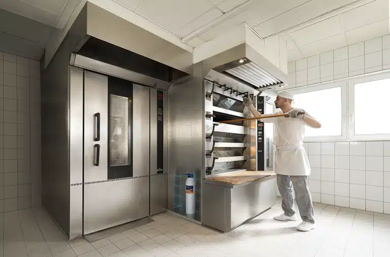 Baker using a commercial oven in a bakery with a water filtration system installed