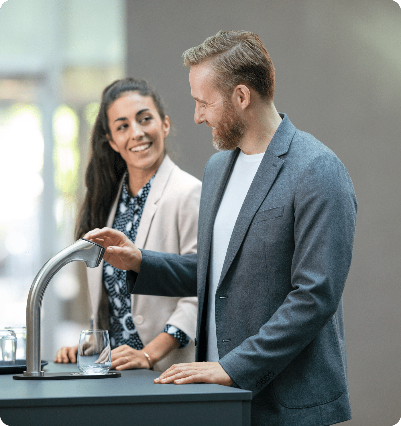 Person using water dispenser with glass