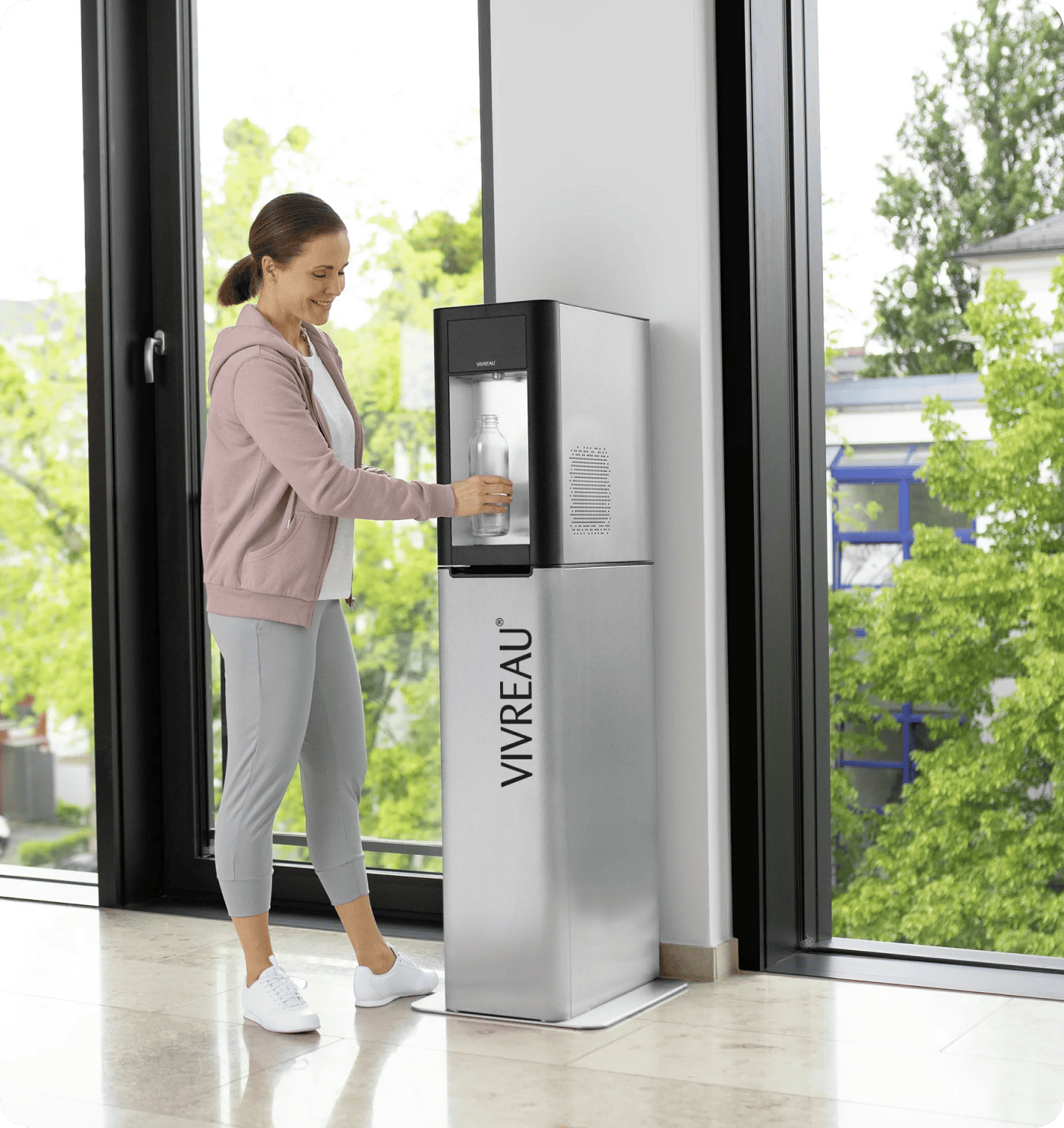 Person using water dispenser with glass