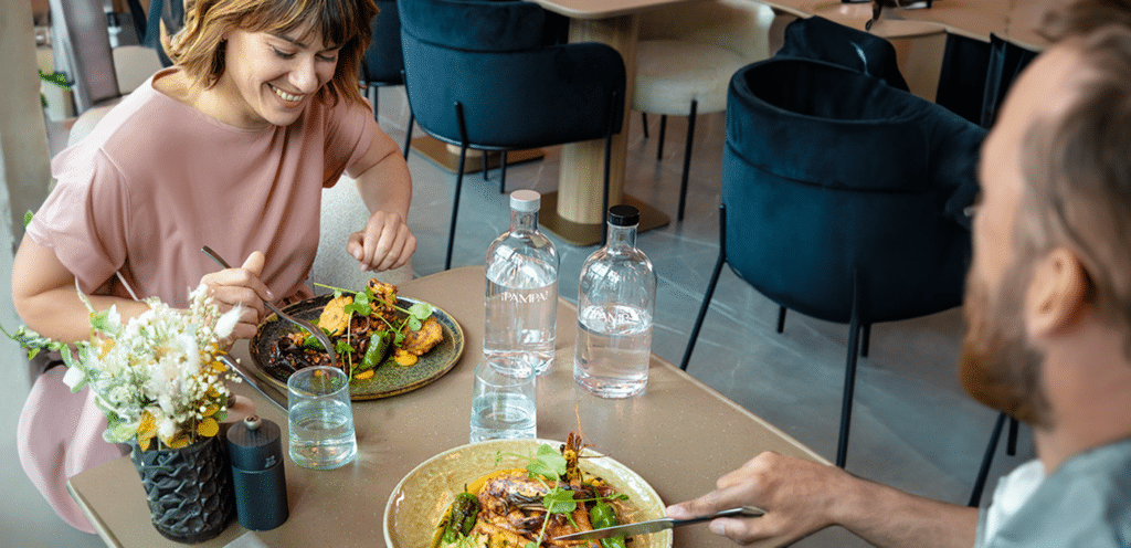 Guests enjoying a meal with sustainable Vivreau water bottles at a hotel restaurant