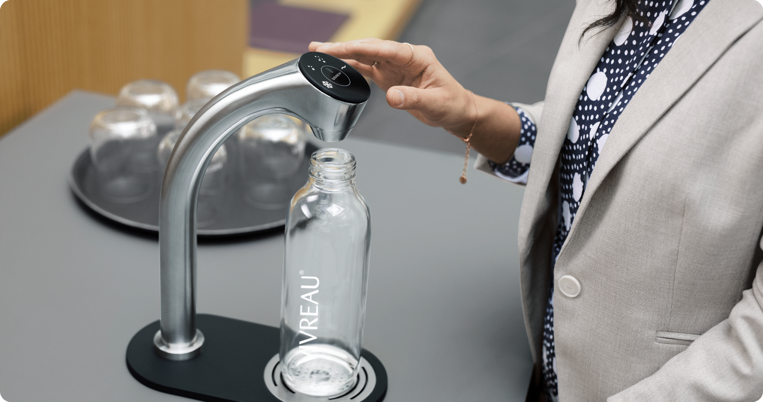 Person using water dispenser in office environment