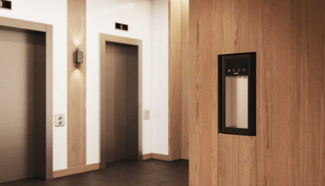 Integrated Vivreau water dispenser installed in a modern elevator lobby with wooden paneling