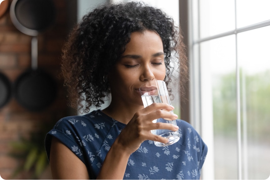 woman enjoying a glass of clean water at home