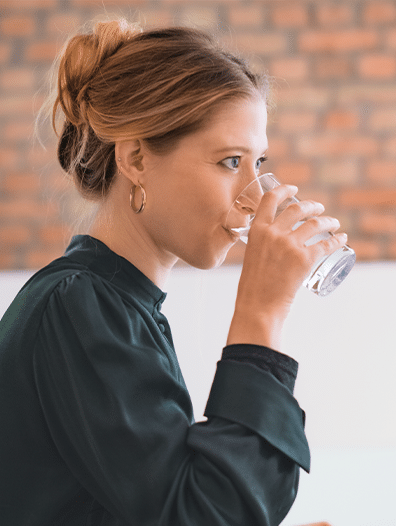 Woman drinking a glass of water indoors