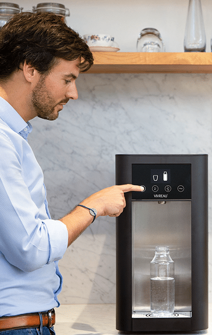 Man using a Vivreau water dispenser to fill a reusable bottle