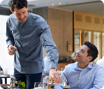 Pouring water out of custom glass bottles in restaurant